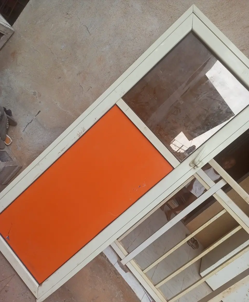 Aluminium sliding window with orange infill and security bars